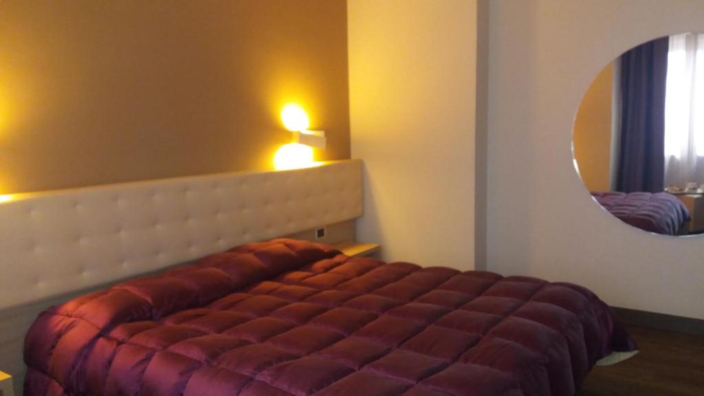 奥斯塔诺登宫殿酒店的一间卧室配有一张带大镜子的床
