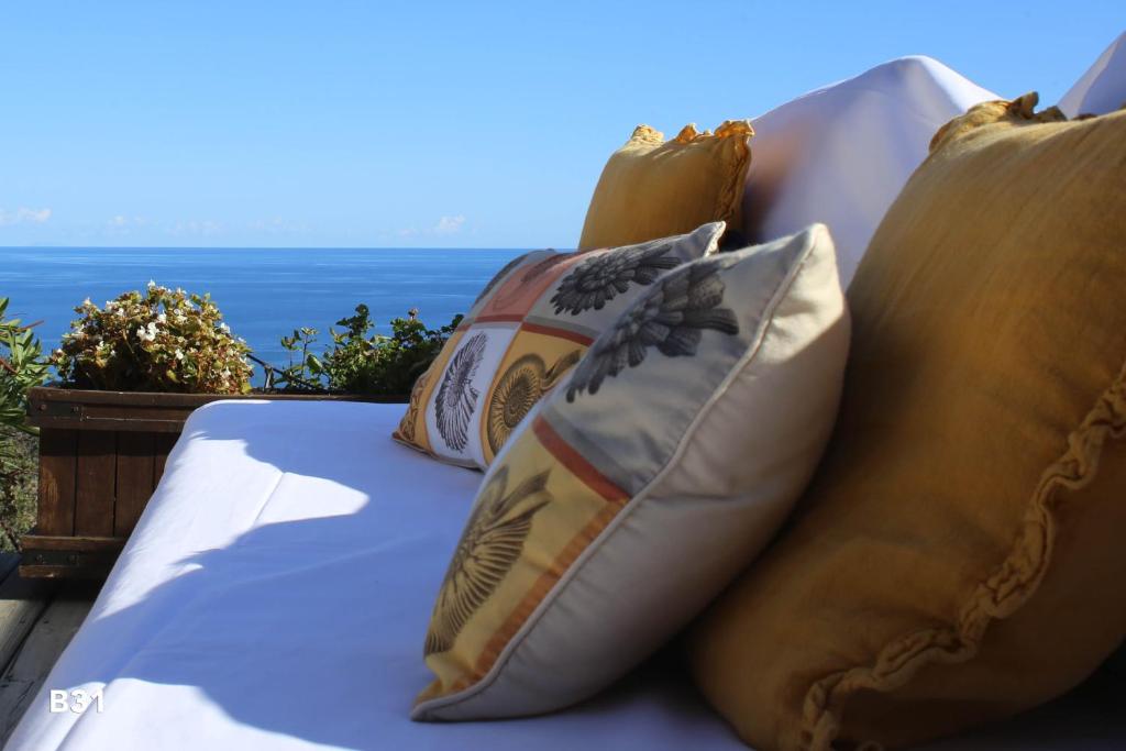 法沃内Villa Vista Mare Residence Serenamore的一张带枕头的床,背靠大海