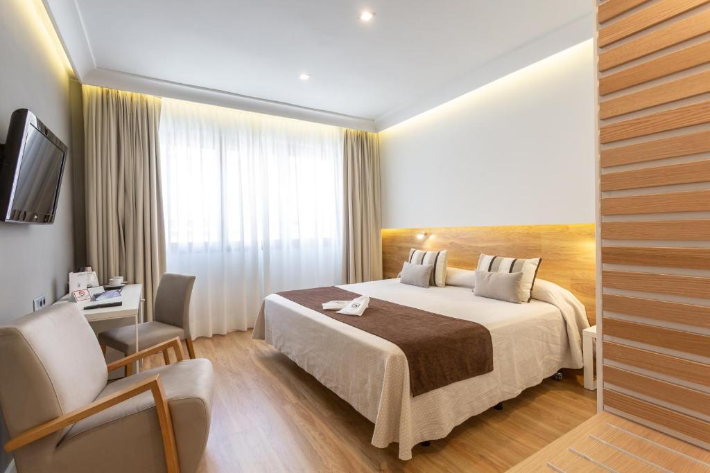 塞维利亚蒙泰卡尔梅洛酒店的配有一张床和一把椅子的酒店客房