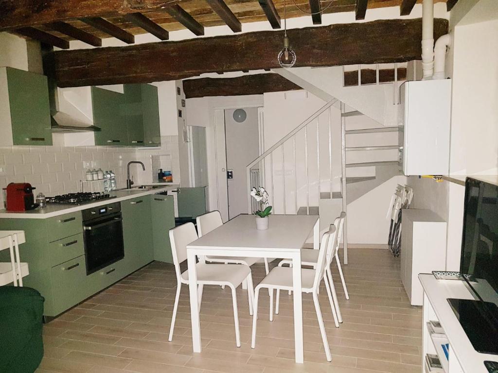 乌尔比诺Casa la Piazzetta Rinascimentale的厨房配有白色的桌子和白色的椅子