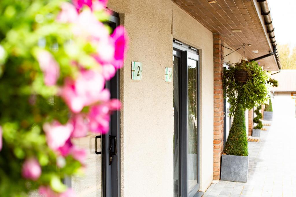 红山布里斯托尔机场住宿加早餐旅馆的一座建筑前面有粉红色花朵的门