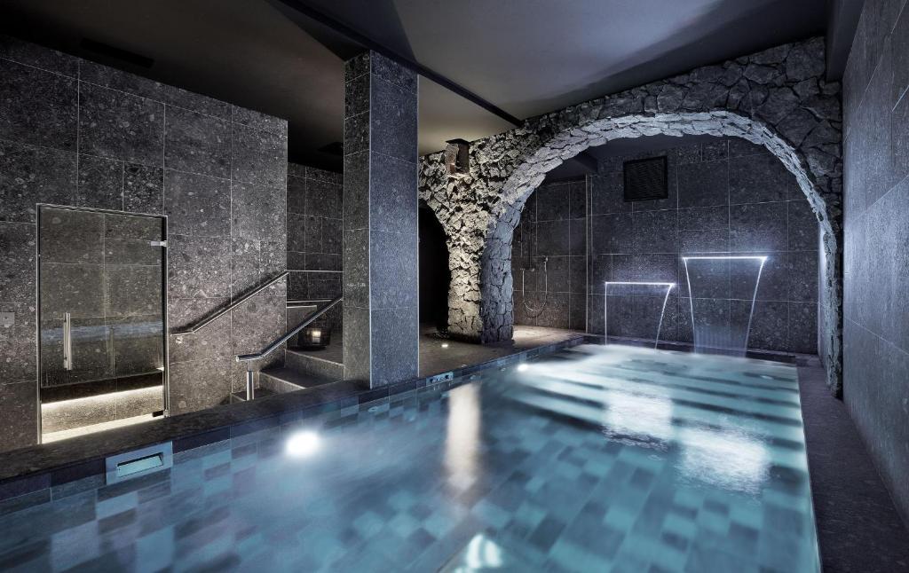 尚贝里机密小酒店的一座游泳池,位于带石墙的浴室内