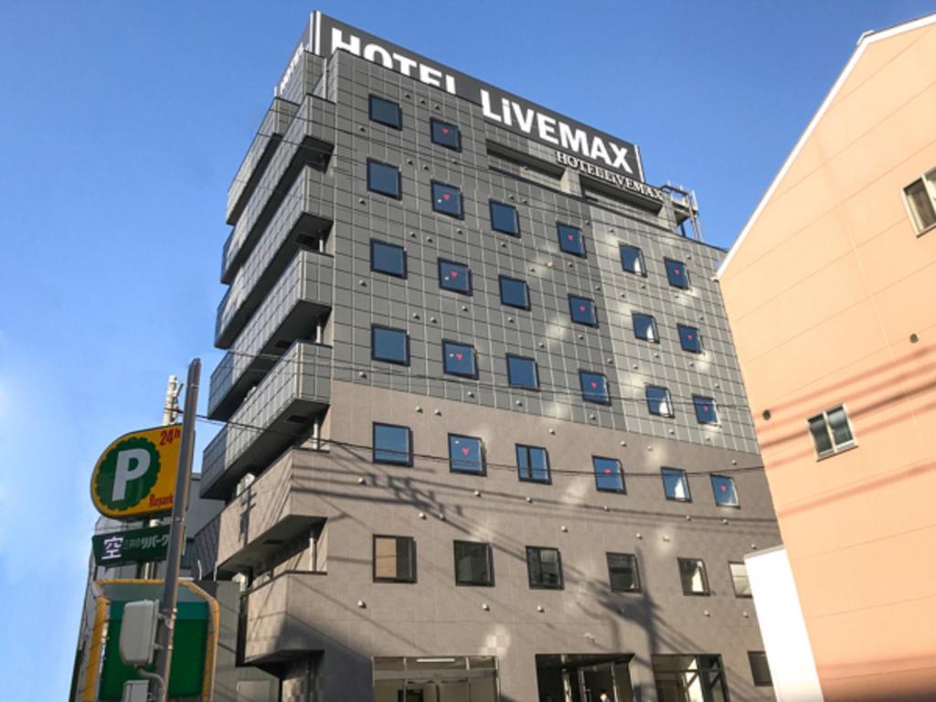 冈山HOTEL LiVEMAX Okayama West的建筑的侧面有标志