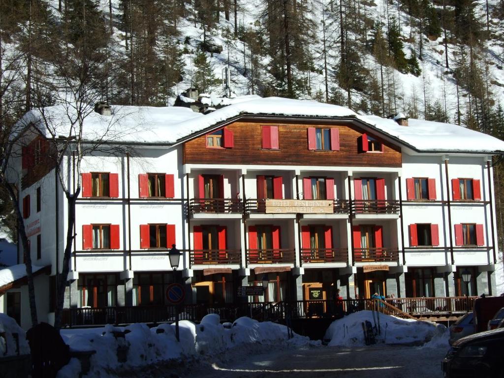 格雷索拉特里尼泰瓦尔维德酒店的一座大建筑,有红色的门,有雪