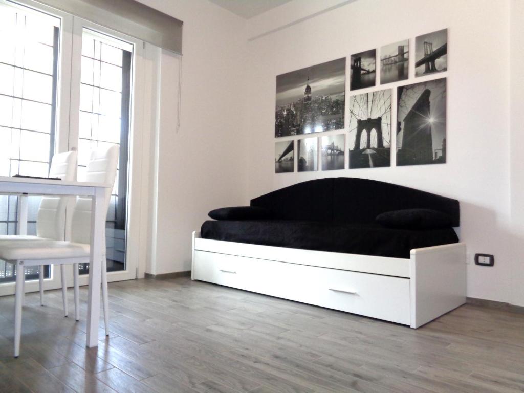 罗马Caput Mundi Anagina IV的白色卧室配有黑色的床和一张桌子