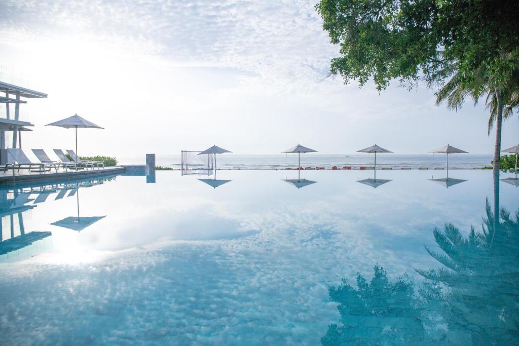 七岩Veranda Resort & Villas Hua Hin Cha Am的一个带遮阳伞的游泳池