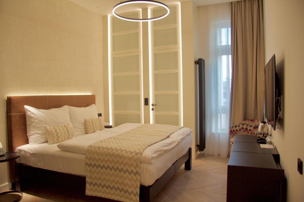 布拉格Chevron Hotel的酒店客房,配有一张床和吊灯