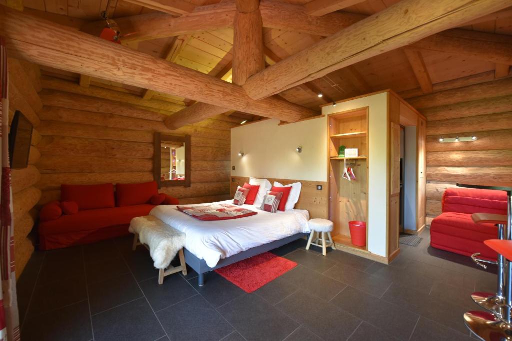 Chazey-sur-Ain马拉莫尔小木屋酒店的一间卧室配有一张床和一张红色的沙发