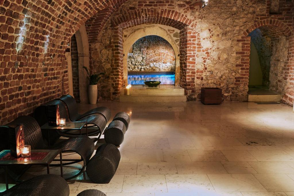 克拉科夫斯塔利酒店的一间设有砖墙和桌椅的房间