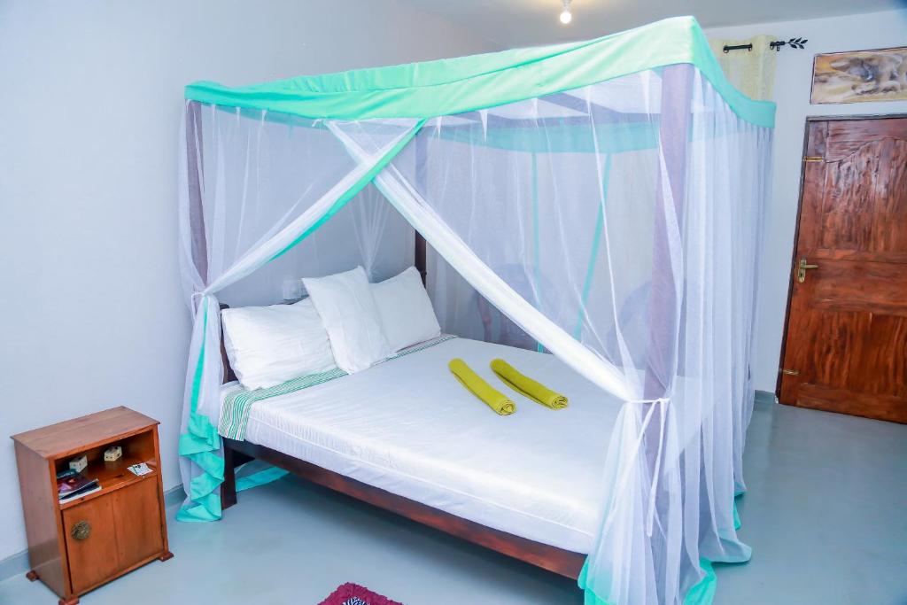 乌纳瓦图纳Greenery Lanka Villa的一间卧室配有一张带两个香蕉的天蓬床