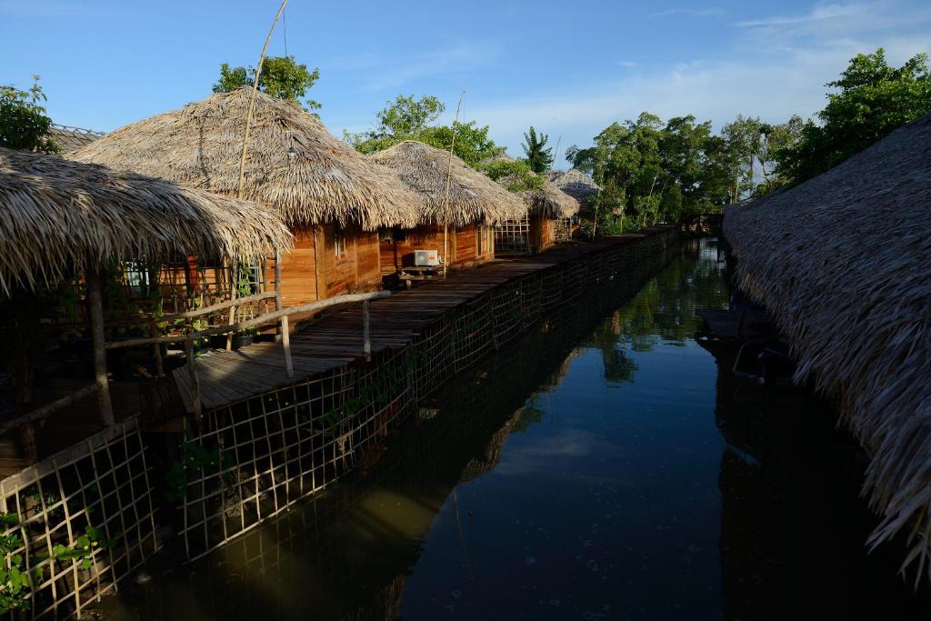帕他仑Baan​ Tonlamphu​ Pakpra的河边一排茅草屋顶的房子