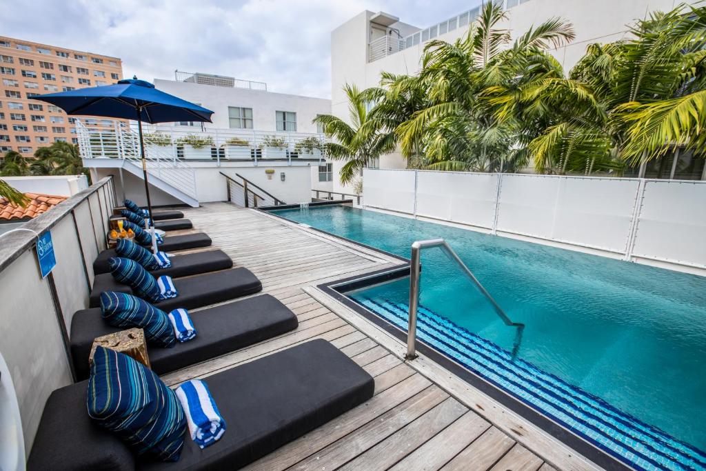 迈阿密海滩珀斯南海滩酒店的一座带躺椅和遮阳伞的建筑屋顶游泳池