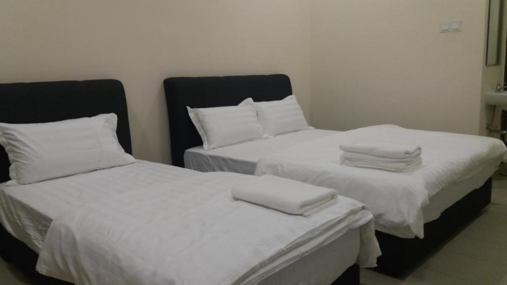 雪邦GLG KLIA Transit House的配有2张床的带白色床单和枕头的客房