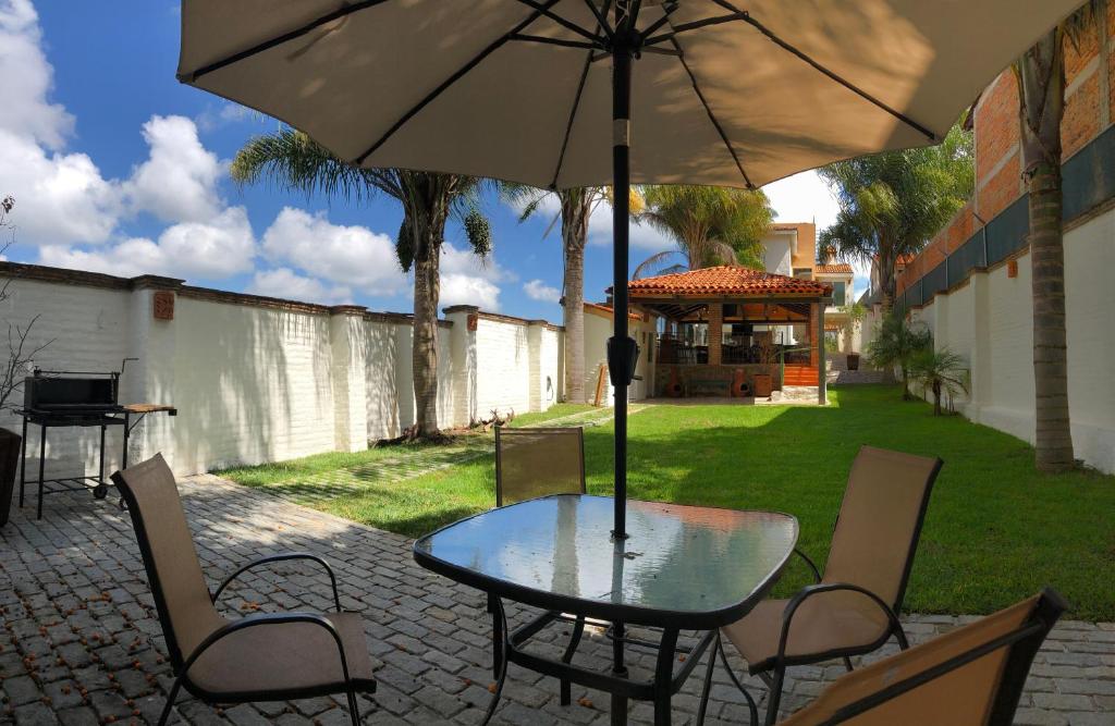 La Manzanilla de la PazCHIFLON VILLAS的庭院内桌椅和遮阳伞