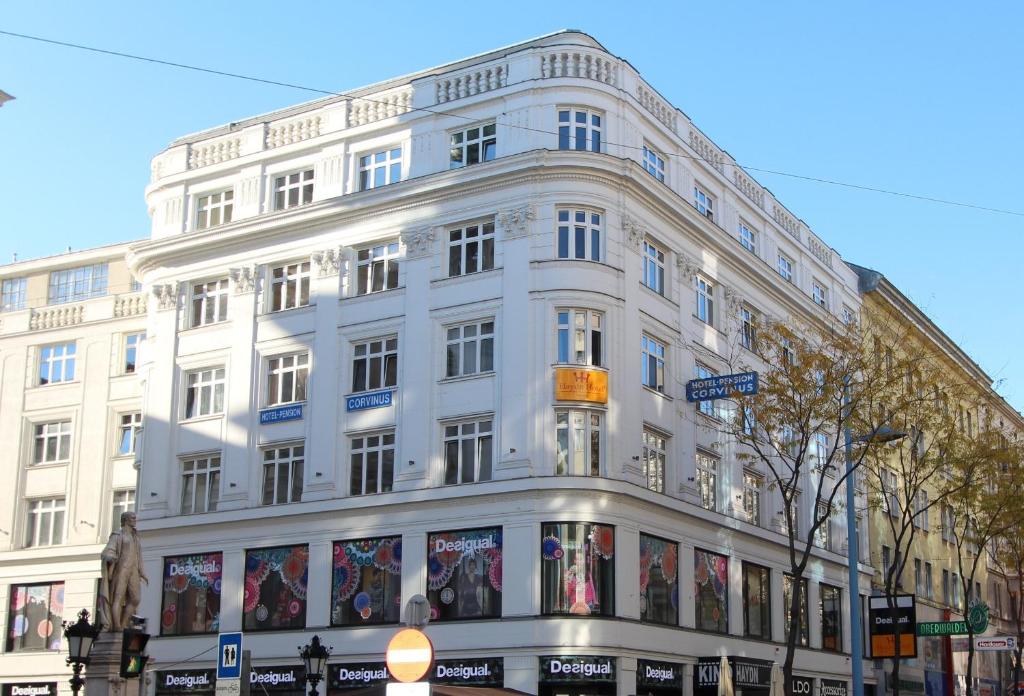 维也纳Hotel Corvinus Vienna - Newly Renovated的街道拐角处的白色建筑
