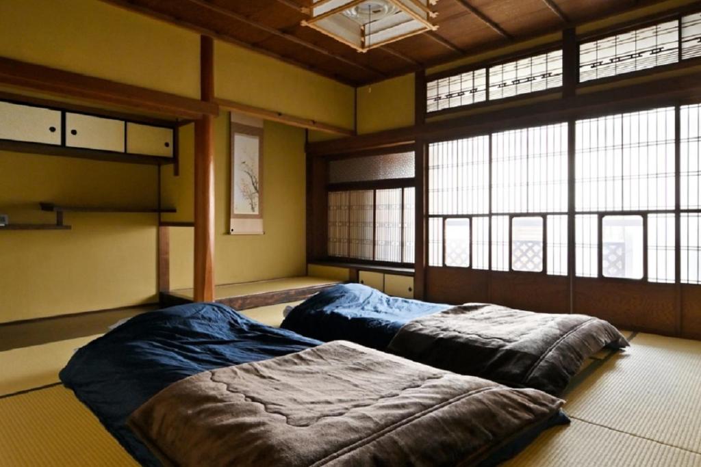 奈良Yuzan apartment Sanjo的大型客房设有2张床和窗户。