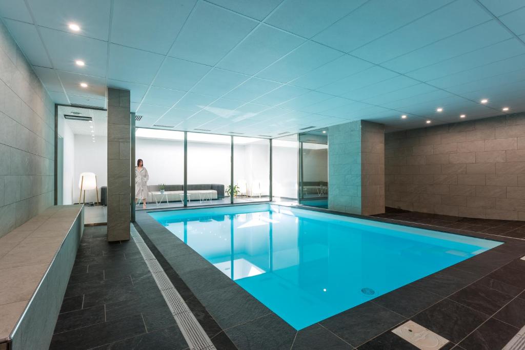 里昂Nemea Appart Hotel So Cloud Lyon Gare Part-Dieu的一座有背景的人的建筑中的游泳池