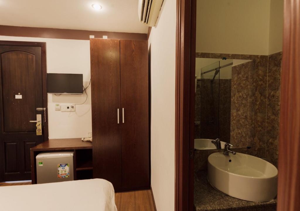 岘港布朗槟2号酒店的一间带水槽、床和浴缸的浴室