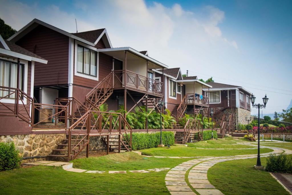 罗纳瓦拉Green Velvet Resort-Near Pawna Lake的一排房子,有楼梯和草