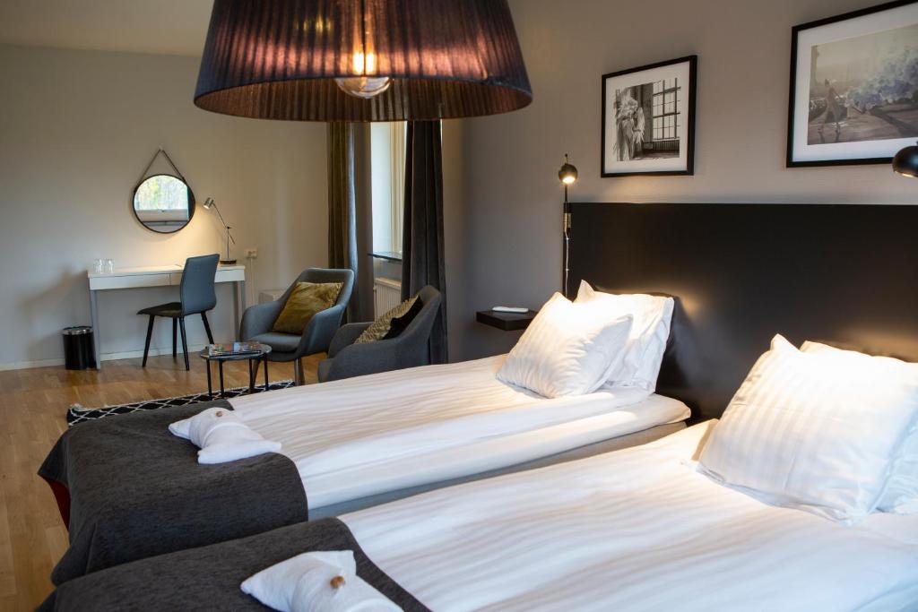 布罗斯Hotell Solhem Park的酒店客房配有两张床和一张书桌