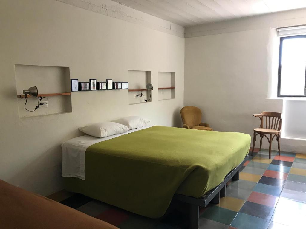 蒂尔卡拉Patio Alto的一间位于客房内的带绿床的卧室