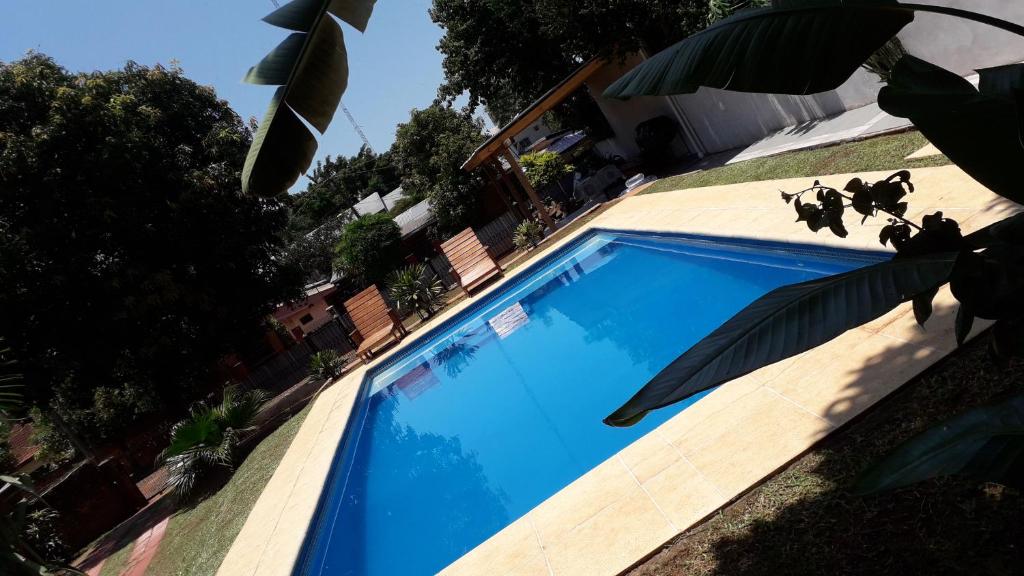 伊瓜苏港Departamento Iguazú Cataratas的房子边的蓝色游泳池