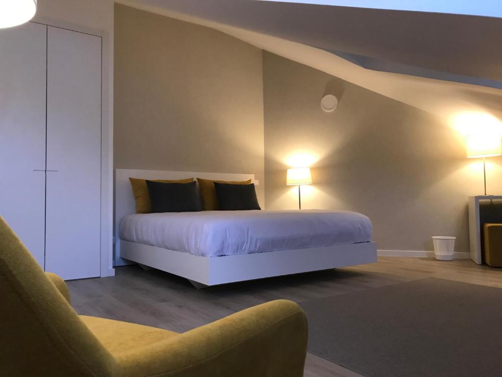 里斯本Lisbon10的一间卧室配有一张带两盏灯和一把椅子的床。