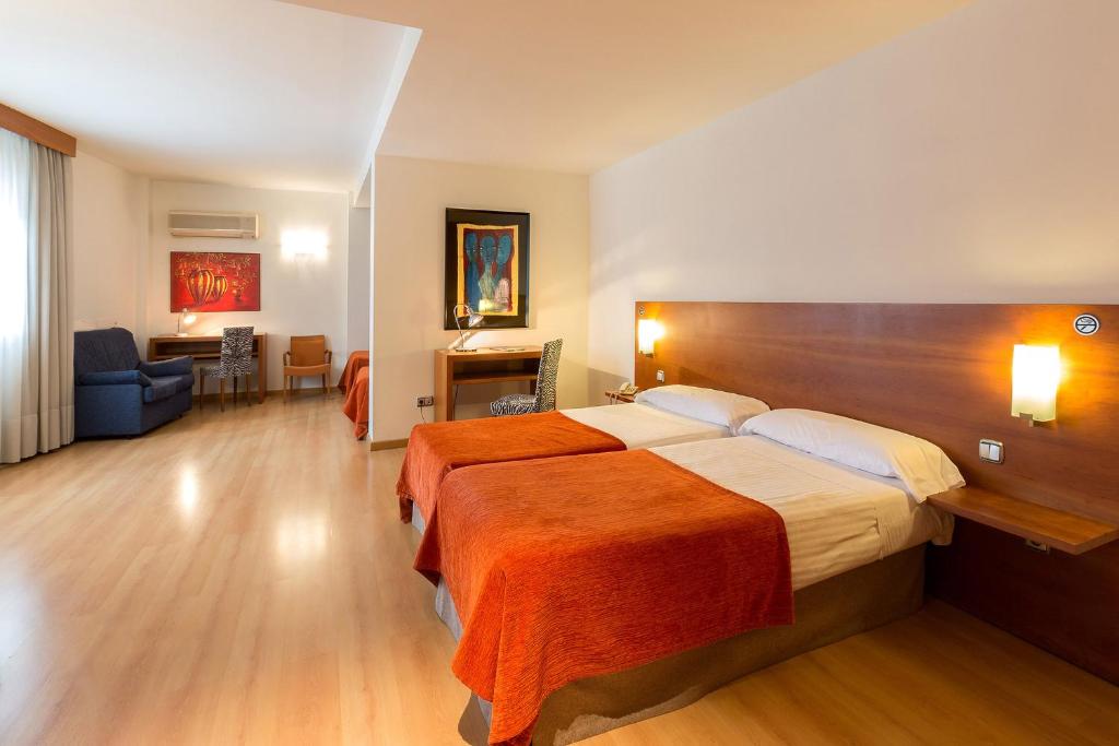 图德拉托雷蒙雷阿尔酒店的一间卧室配有一张带橙色毯子的大床