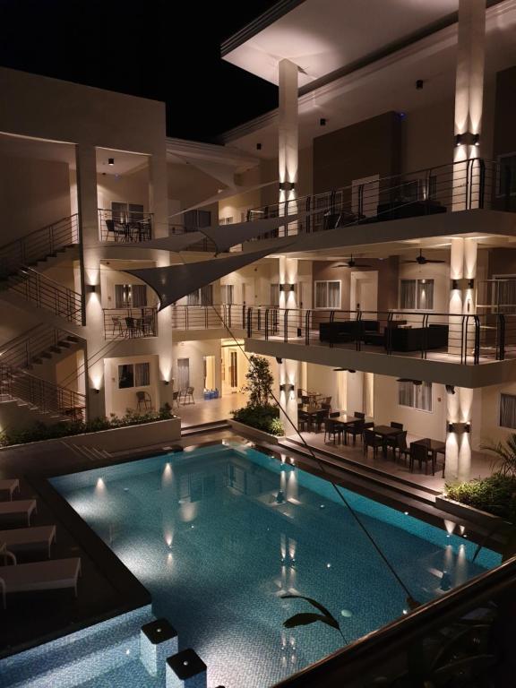 杜马格特Rovira Suites的一座游泳池,在晚上在建筑物前