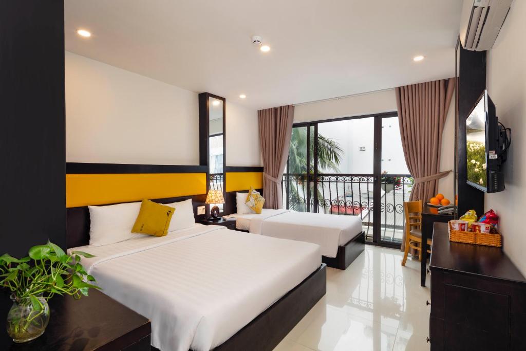 芽庄Tokia Hotel Nha Trang的酒店客房设有两张床和一个阳台。