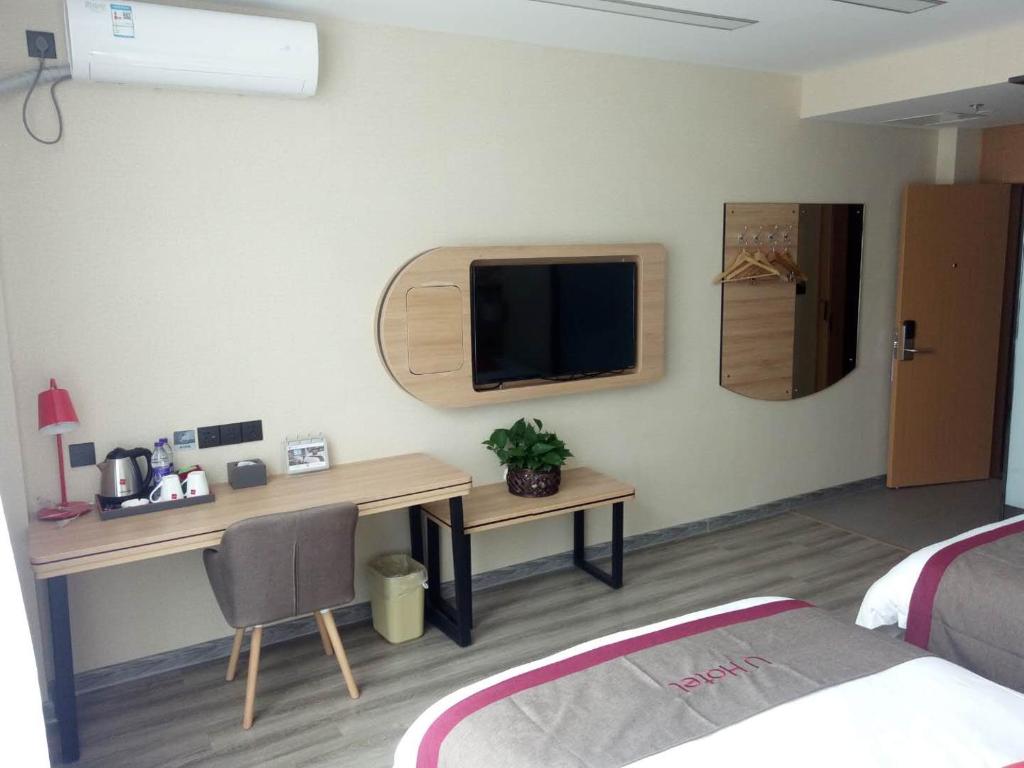 宣城尚客优精选安徽宣城宣州区盛世御景店的一间卧室配有一张桌子和一台墙上的电视。