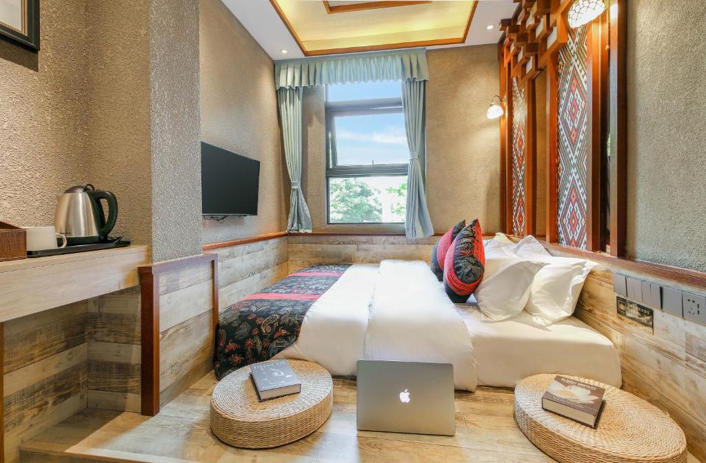 重庆走去野旅行酒店的一间卧室配有一张带笔记本电脑的床