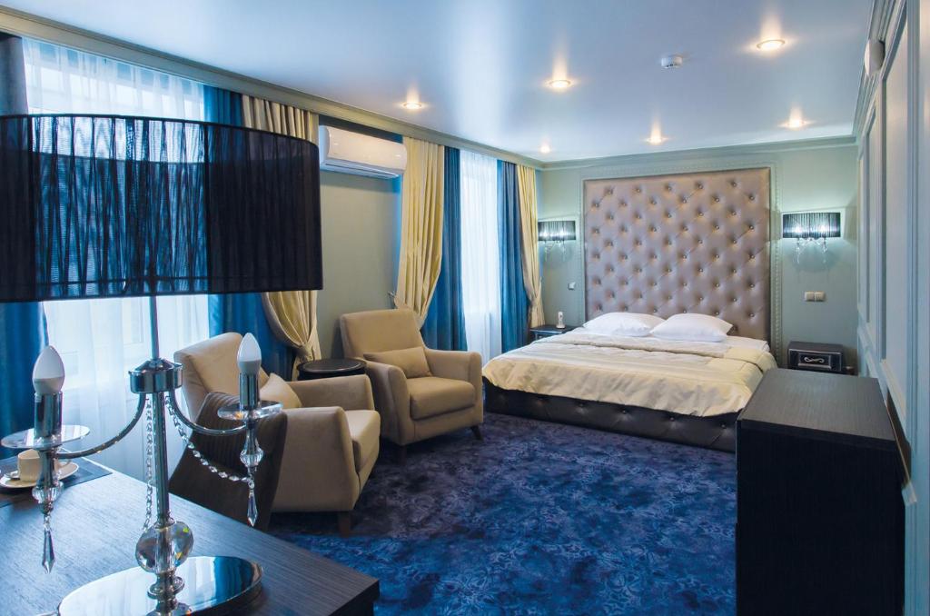 克拉斯诺亚尔斯克雪鸮酒店的配有一张床和一把椅子的酒店客房