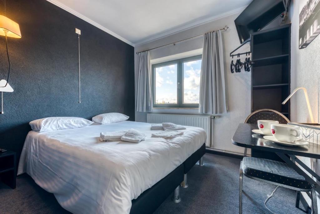 维塞Hôtel de la Gare的配有一张床和一张书桌的酒店客房