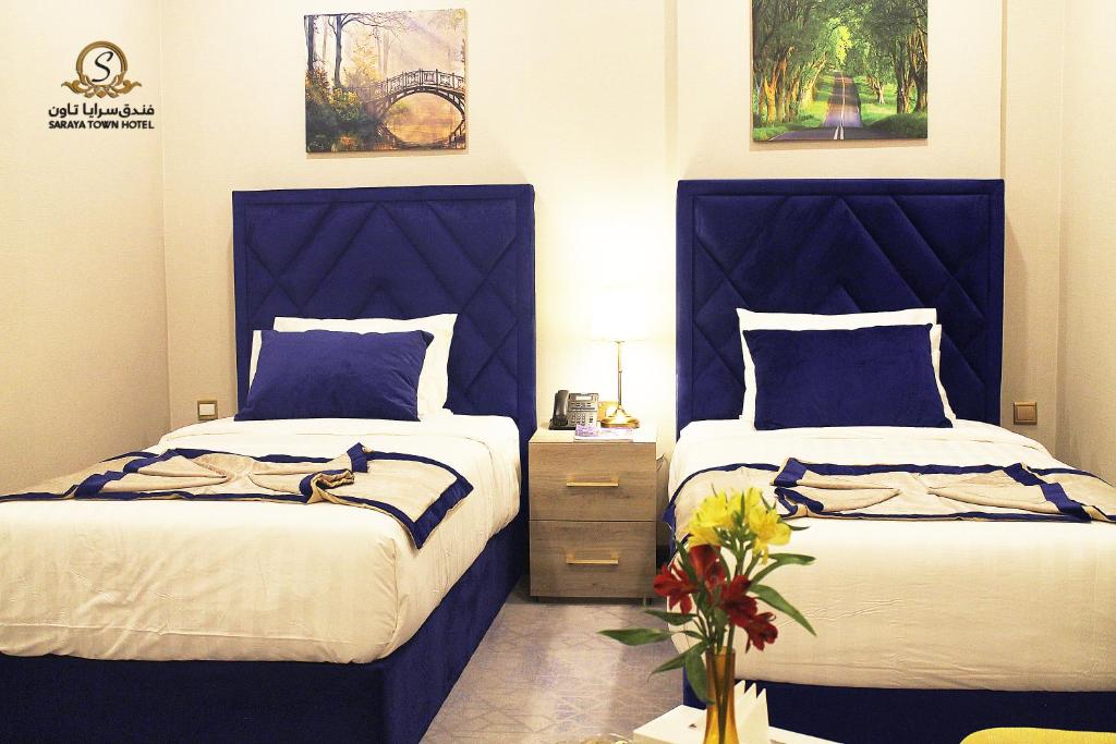 多哈Saraya Palace Hotel的卧室内的两张床和蓝色床头板