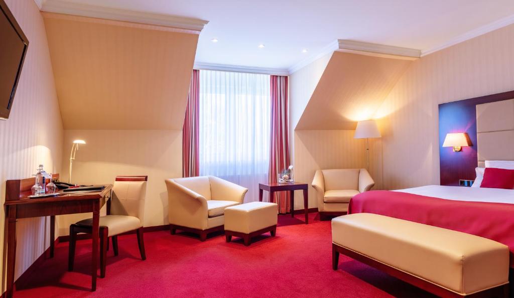 不来梅港阿马里斯酒店的酒店客房,配有一张床、一张桌子和椅子