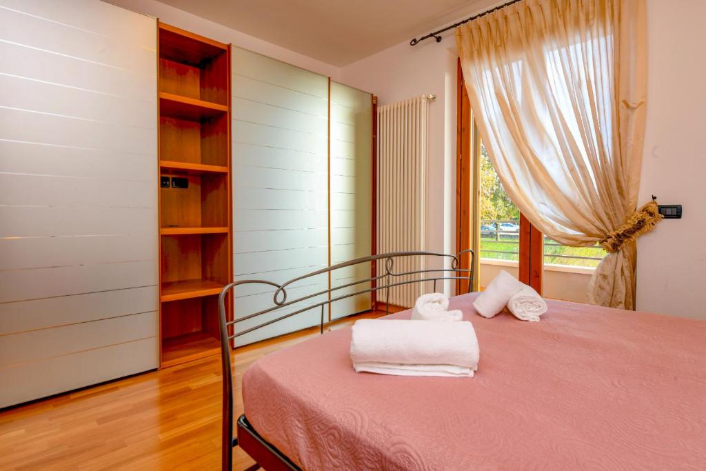 佩斯基耶拉德加达My Peschiera Family Home XL的一间卧室配有带毛巾的床
