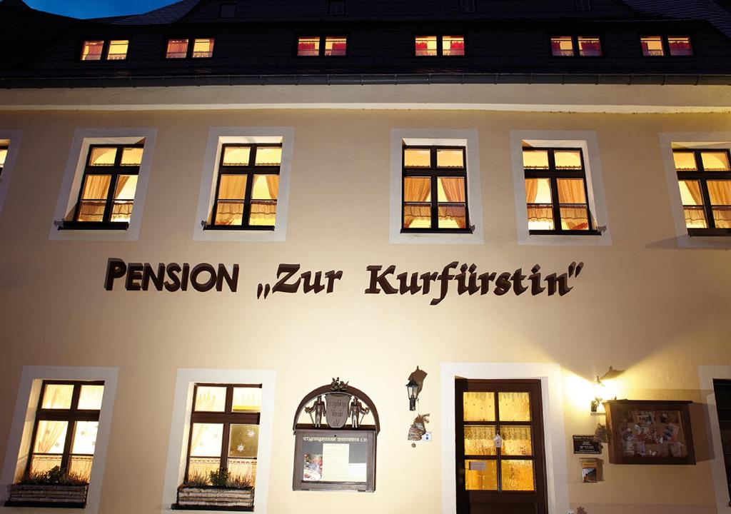 沃尔肯施泰因Pension zur Kurfürstin的白色的建筑,旁边标有标志