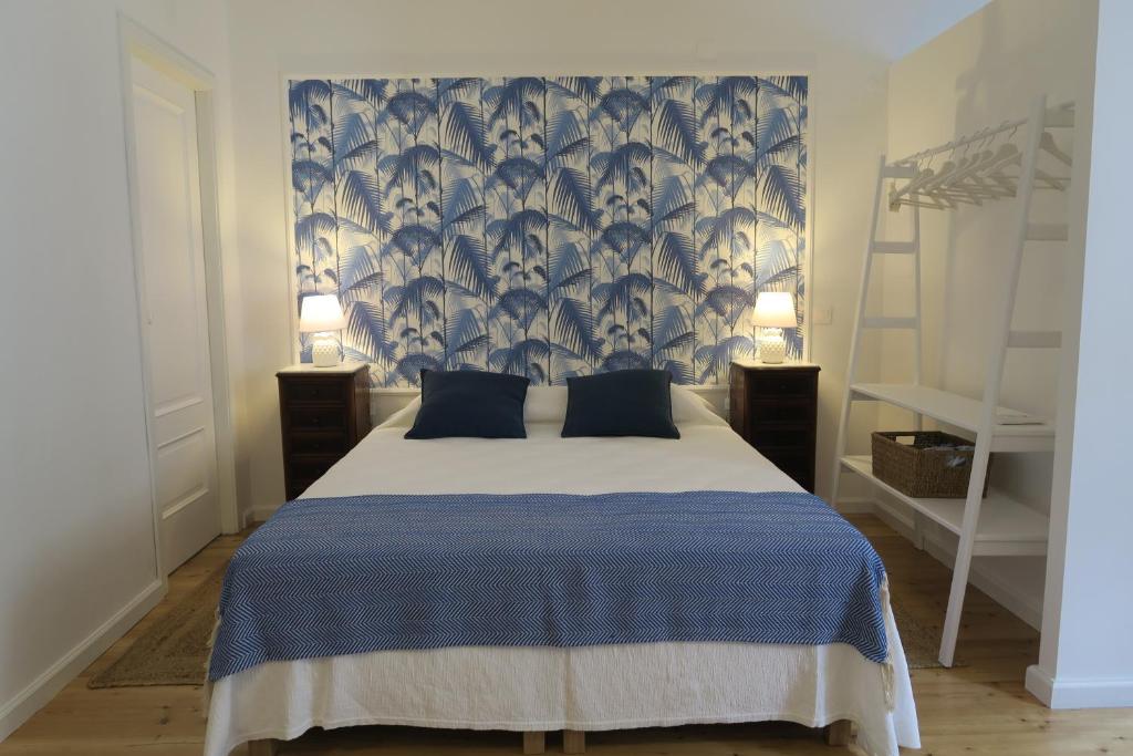 塔维拉Azul Sul的一间卧室配有一张带蓝白色毯子的床