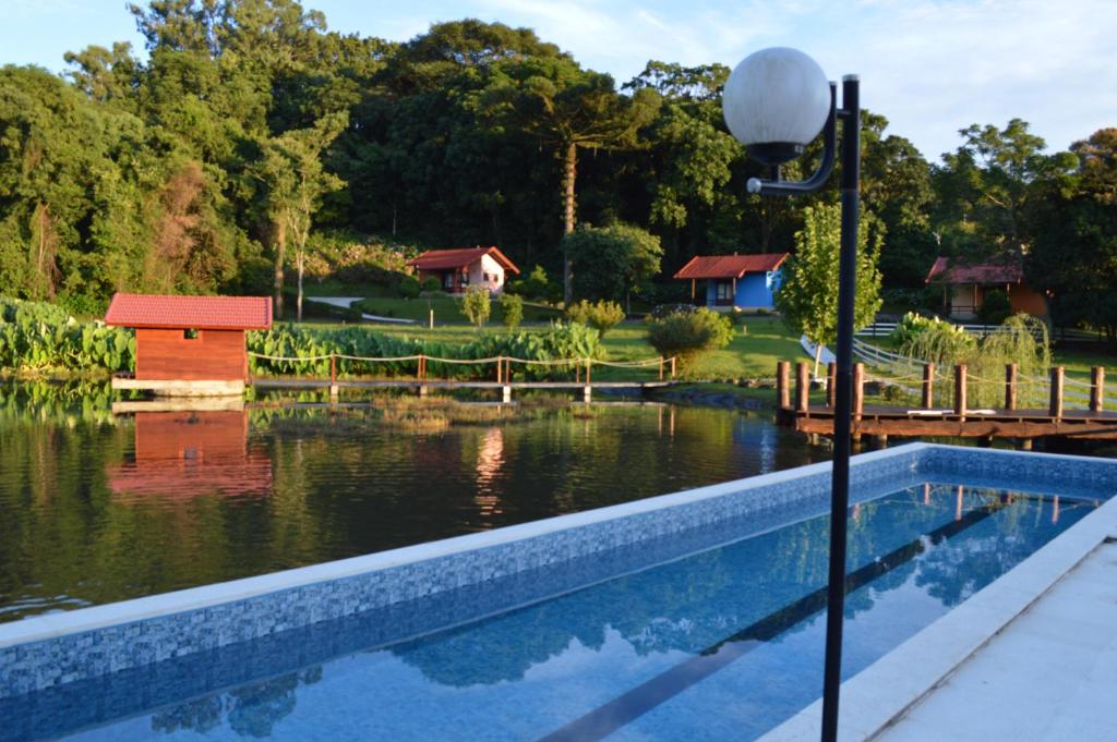 新彼得罗波利斯蒲萨达皮哈勒奥拓酒店的湖畔游泳池,带房子