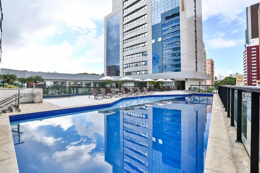 萨尔瓦多Quality Hotel & Suítes São Salvador的一座带椅子的游泳池以及一座建筑
