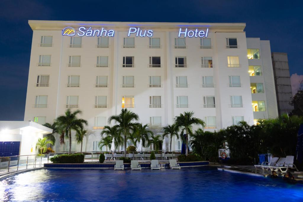圣玛尔塔Sanha Plus Hotel的前面有一个游泳池的酒店