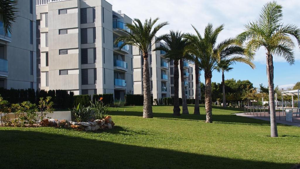 埃尔斯波夫莱特斯Apartamentos Verger de Denia的一座棕榈树公园,位于一座建筑前