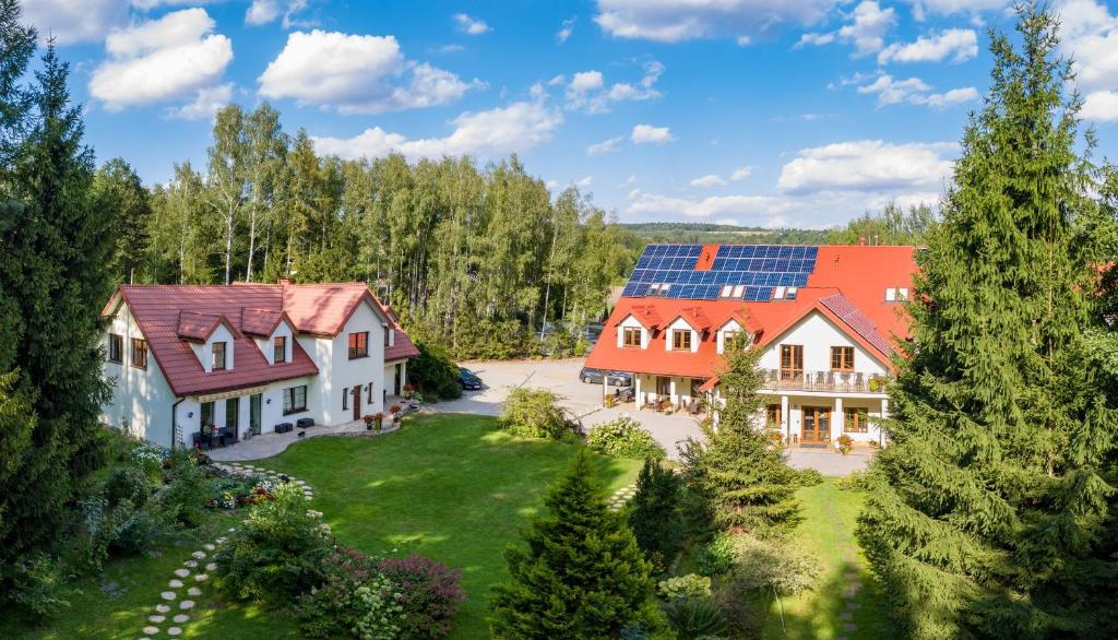 CisówPensjonat Leśny Dworek SPA & Garden Uzdrowisko wśród Natury的屋顶上太阳能电池板房子的空中景观
