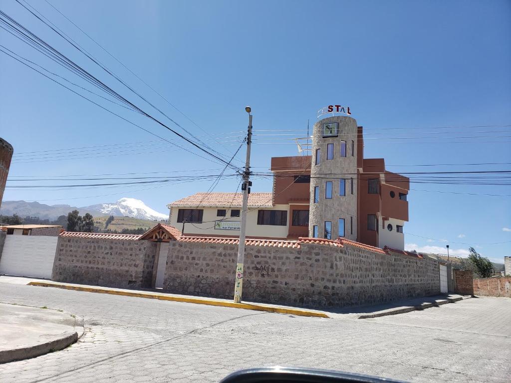 卡扬贝Hospedaje San Fernando的砖墙旁的钟楼