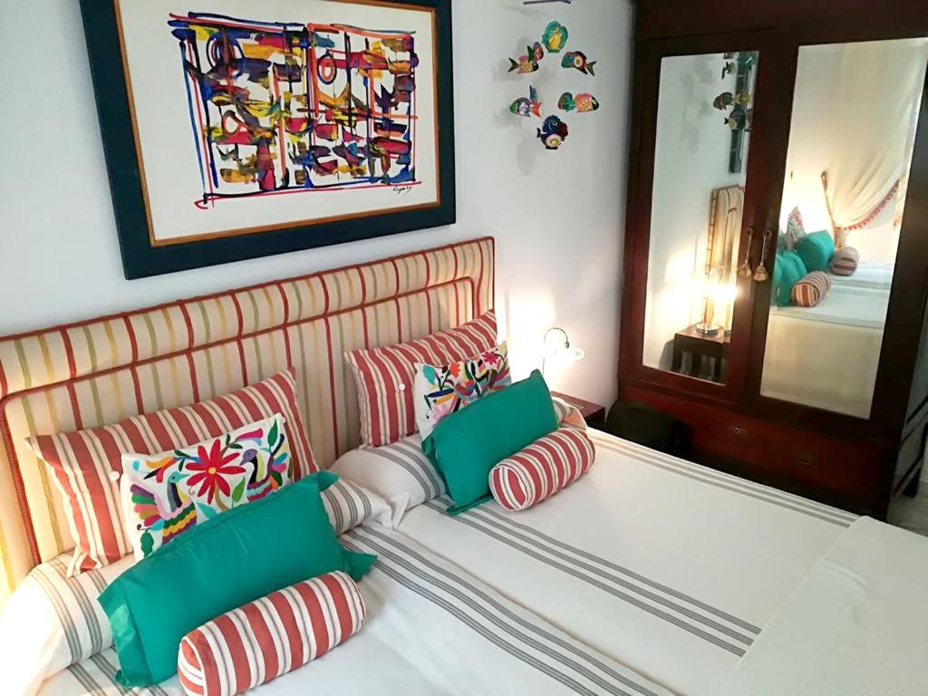 罗塔2 bedrooms appartement at Rota 50 m away from the beach with city view and wifi的一间卧室配有带绿色和红色枕头的床