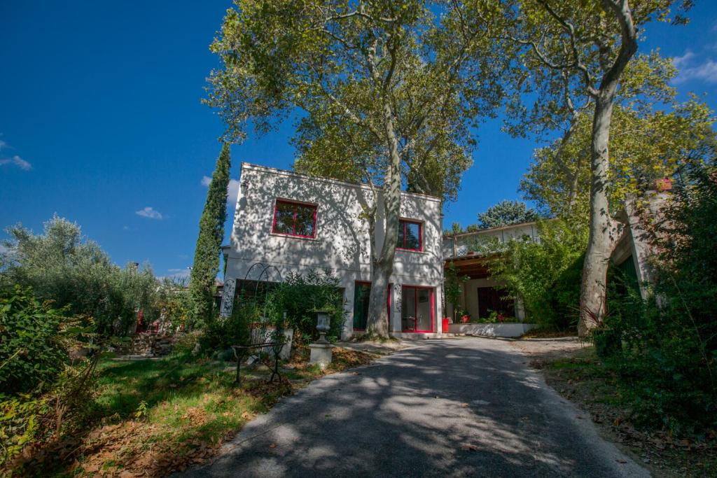于泽斯Duché d'Uzès Villa Celina Avenue des Cévennes的路边有红色窗户的灰色房子