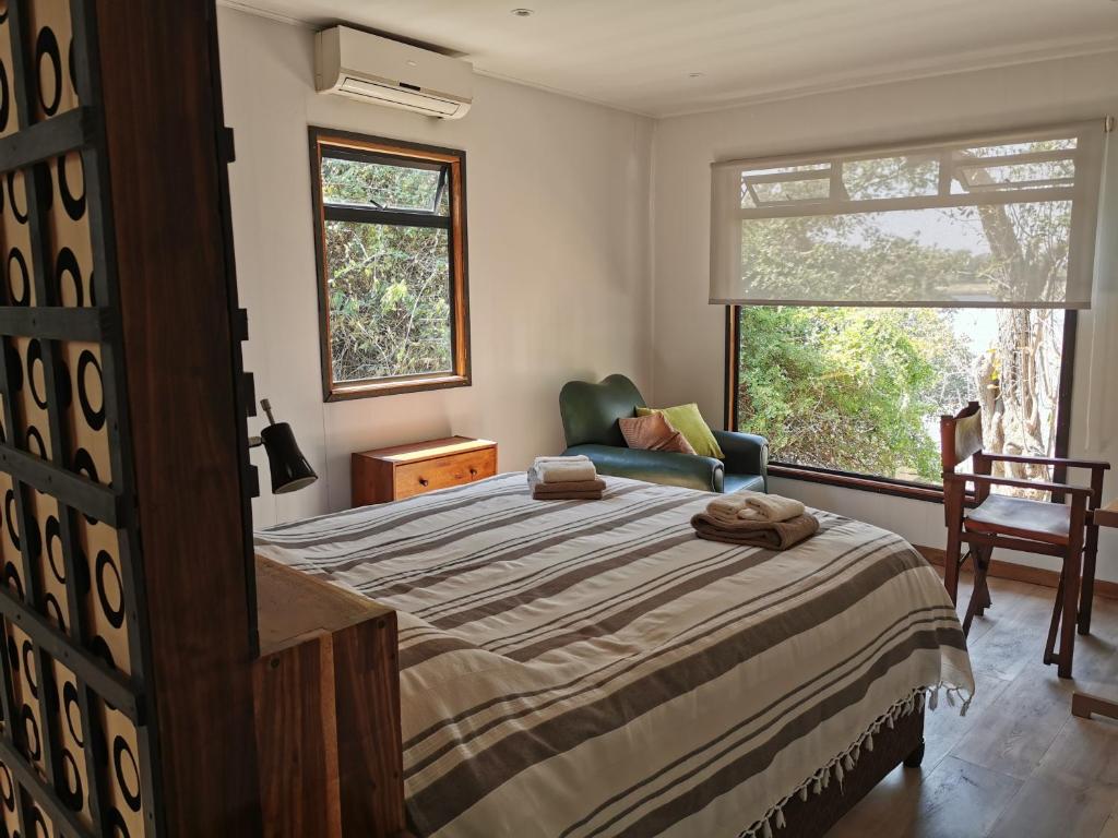 利文斯顿Mama Out of Africa的卧室配有床、椅子和窗户。