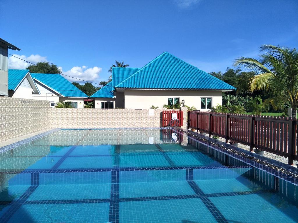 丹绒鲁DVilla Guesthouse Langkawi的房屋前的游泳池