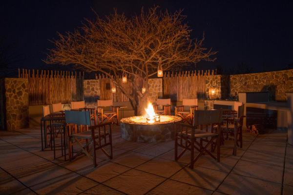 MatlhagameNtamba Safari Lodge的火坑,带椅子,桌子和树